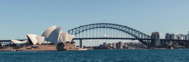 Sydney Opera House and Sydney Harbour Bridge with clear blue sky, viewed from across the harbor during daytime