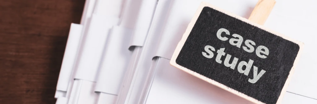 A small chalkboard sign reading case study beside stacks of white documents on a desk.