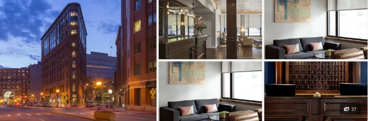 Hotel in Boston at dusk, a reception area with a wooden desk, a cozy seating area with sofas, and a vintage key organizer.
